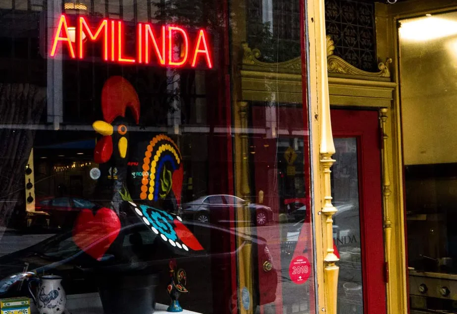 Painted rooster and neon Amilinda sign in the restaurant's front window